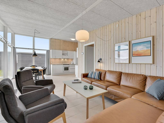 De comfortabele zithoek met een leren bank en fauteuils in de woonkamer van een Design Plus vakantiewoning in Lalandia.