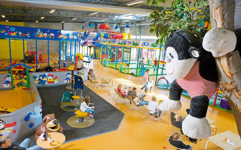 Overzicht van de grote indoor speeltuin Monky Tonky Land bij Lalandia, met speeltoestellen, een knutselhoek en zitjes.
