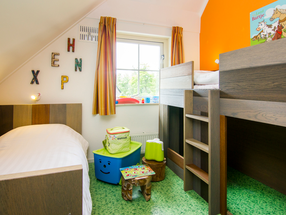 Een vrolijk ingerichte kinderslaapkamer met een stapelbed, een los bed en leuke details in een van de accommodaties op Landal het Land van Bartje.