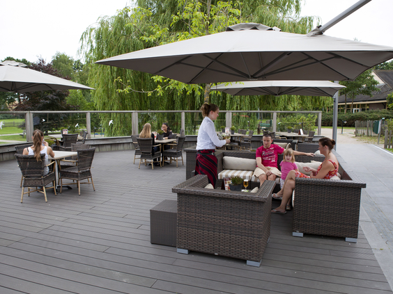 Buitenlounge met terrasmeubilair en grote parasol bij Landal Aelderholt