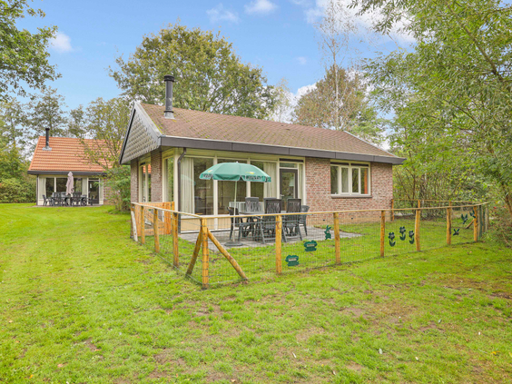 Een vrijstaande bungalow op Landal Aelderholt in Drenthe met een ruime, omheinde tuin, terras en een eigen klein speeltoestel voor de kinderen.