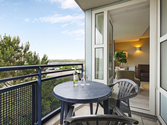 Balkon van een appartement bij Landal Ameland State met een zitje en prachtig uitzicht over de duinen en natuur van Ameland.