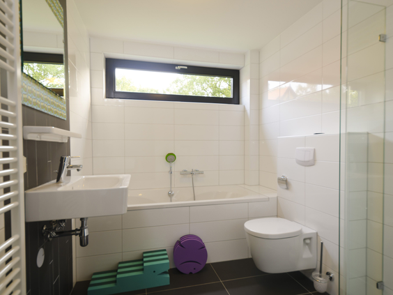Een lichte en moderne badkamer in een vakantiehuis op Landal Amerongse Berg, compleet met een comfortabel ligbad.