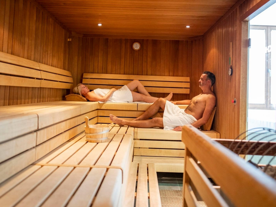 Gasten ontspannen in de ruime, houten sauna van Landal Arber, onderdeel van de wellnessfaciliteiten op het park.