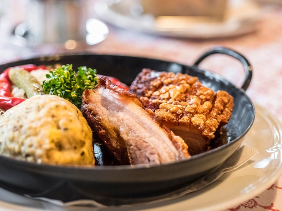 Een traditioneel en stevig Beiers gerecht geserveerd in een zwarte pan in het restaurant van Landal Arber.