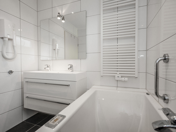 Nette, witte badkamer met een ligbad en douche in een vakantiehuis op Landal Beach Park Texel.
