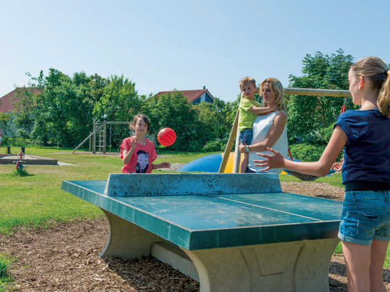 Kinderen spelen tafeltennis in de buitenspeeltuin van Landal Beach Park Texel op het eiland Texel.