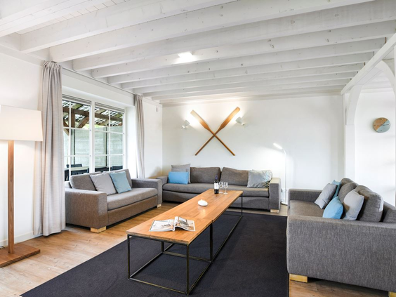 De sfeervolle en ruime woonkamer van een vakantievilla op Landal Beach Resort Ooghdyne, met comfortabele banken.