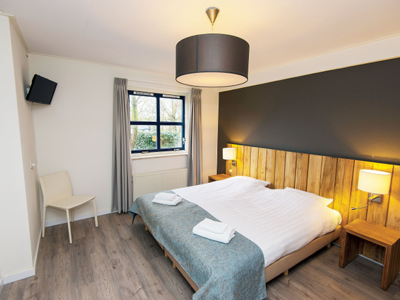Een comfortabele tweepersoons slaapkamer in een villa van Landal Beach Resort Ooghdyne, sfeervol ingericht.