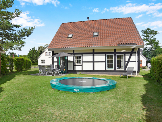 Een karakteristiek vakwerkhuis op Landal Cauberg met een grote, eigen trampoline in de groene tuin.