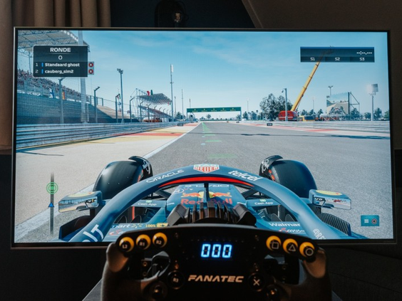 Close-up van de professionele race-simulator in een vakantiehuis op Landal Cauberg, met het stuur en het scherm waarop het racespel te zien is.