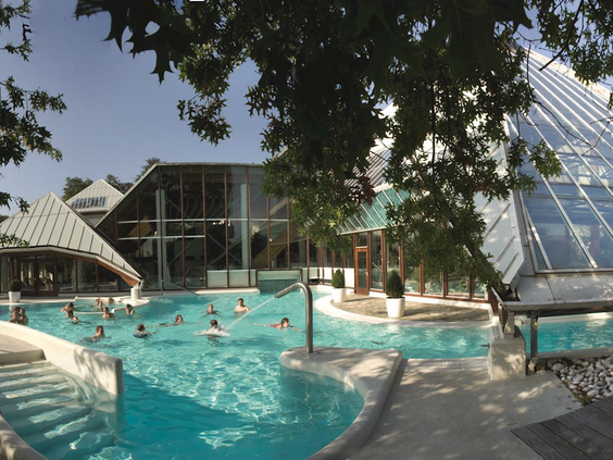 Het thermaal buitenzwembad van wellnesscentrum Thermae 2000 in Valkenburg, waar gasten ontspannen in het warme water.