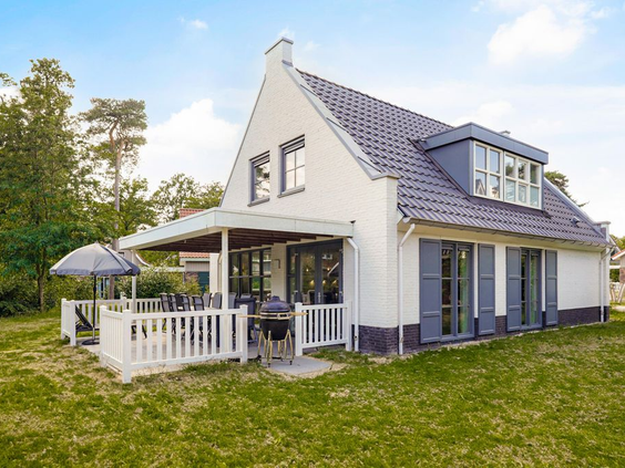 Grote, witte vrijstaande bungalow met een ruim grasveld en overdekt terras op vakantiepark Landal De Vers.
