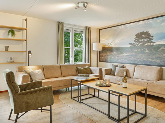 Sfeervolle woonkamer in een bungalow op Landal De Vers met een comfortabele hoekbank en moderne inrichting.