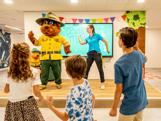 Kinderen dansen en zingen samen met Bollo de beer en het animatieteam op Landal De Vers.