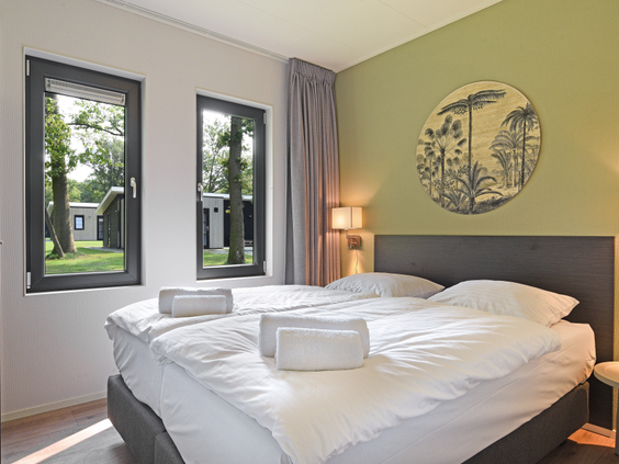 De rustgevende slaapkamer in een bungalow op Landal De Vlinderhoeve met een comfortabel, opgemaakt tweepersoonsbed.