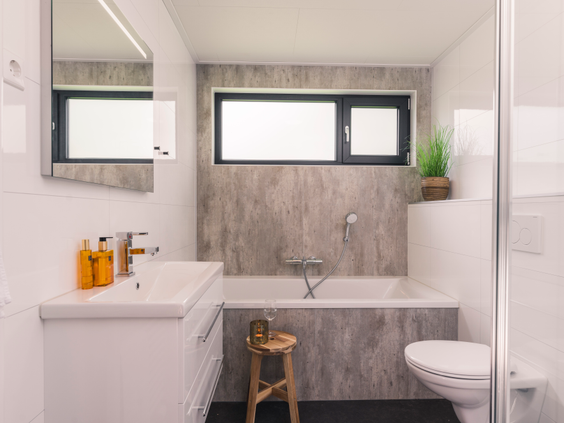 De moderne en lichte badkamer in een bungalow op Landal De Vlinderhoeve, uitgerust met een ligbad.