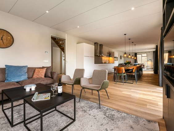 De moderne en sfeervolle inrichting van de woonkamer en keuken in een luxe vakantiewoning op Landal De Wedderplassen.
