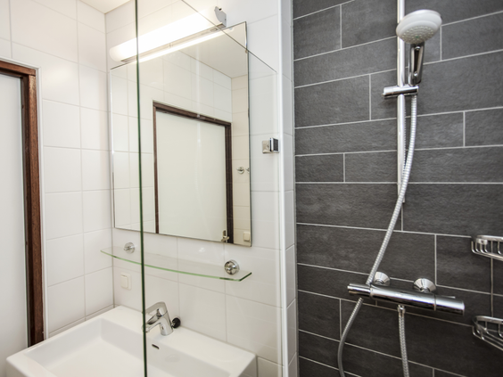 De vernieuwde, moderne badkamer in een bungalow op Landal Heideheuvel, voorzien van een wastafel en een comfortabele inloopdouche.