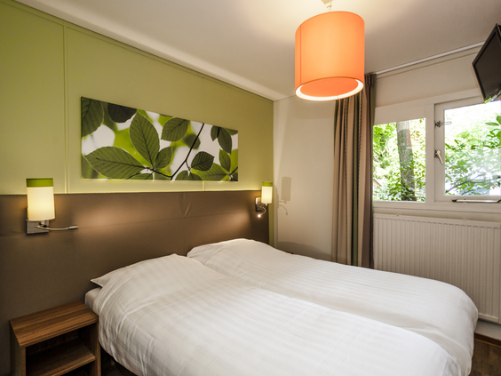 Een netjes opgemaakt tweepersoonsbed in de comfortabele slaapkamer van een bungalow op Landal Heideheuvel.