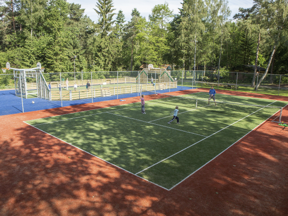 Kinderen spelen op het multifunctionele sportveld voor voetbal en basketbal, gelegen in de bossen van Landal Heideheuvel op de Veluwe.