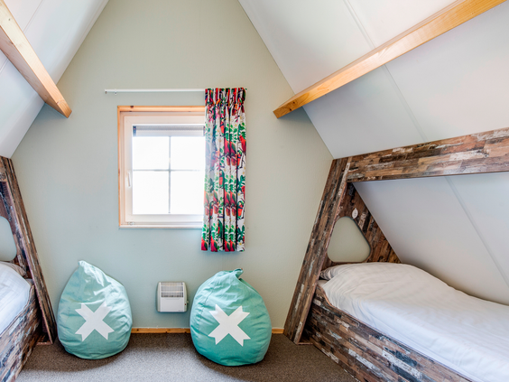 Een gezellige kinderslaapkamer met bedsteden en vrolijke zitzakken in een bungalow op Landal Hellendoornse Berg.