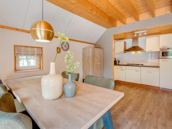 De sfeervolle eethoek en de moderne, open keuken in een van de bungalows op Landal Hellendoornse Berg.