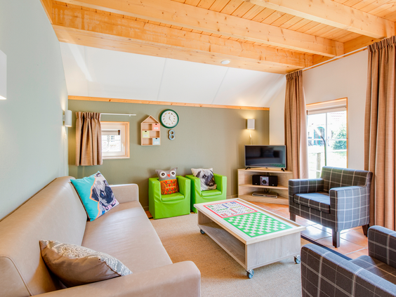Ruime woonkamer in een kinderbungalow op Landal Hellendoornse Berg, compleet met een veilige box voor de allerkleinste gasten.
