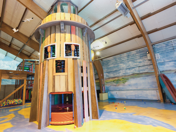 De hoge houten klimtoren in het indoorspeelparadijs van Landal Hochwald, met meerdere verdiepingen om te ontdekken.