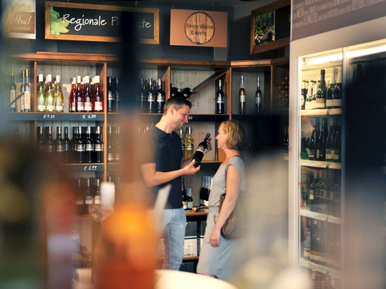Gasten kiezen een drankje in de sfeervolle bar of vinotheek van het restaurant op Landal Hochwald.