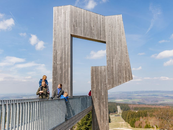 Bezoekers op het moderne, houten uitkijkplatform 'Perspektive' dat een spectaculair uitzicht biedt over de rivierbocht Saarschleife, een bezienswaardigheid nabij Landal Hochwald.
