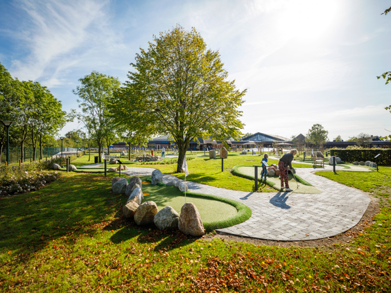 Een gezin speelt Adventure Golf op de prachtig aangelegde 18-holes golfbaan in de buitenlucht bij Landal Hof van Saksen.