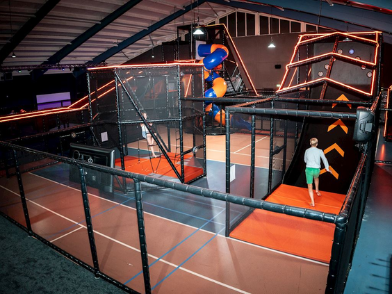 Het grote indoor trampolinepark met diverse klim- en springparcoursen waar een kind aan het rennen is op Landal Hoog Vaals.