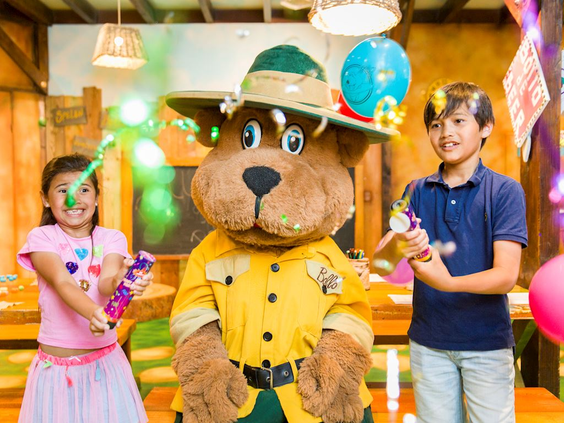 Twee kinderen vieren feest met confetti naast Bollo de Beer tijdens een kinderactiviteit op vakantiepark Landal Hoog Vaals.
