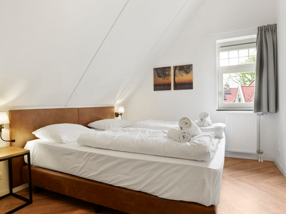 De sfeervolle slaapkamer met een opgemaakt tweepersoonsbed in een van de comfortabele vakantiehuizen op Landal Kaatsheuvel.