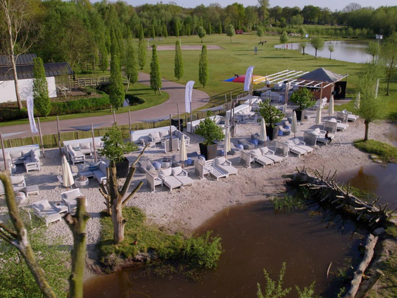Overzicht van boven van de grote, avontuurlijke waterspeeltuin met rotsen, zand en waterpartijen op vakantiepark Landal Klein Oisterwijk.