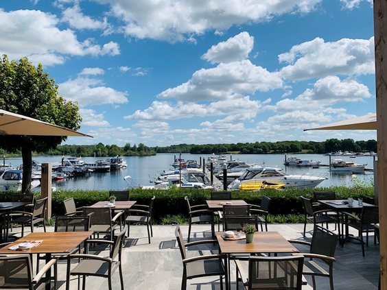 Het terras van het restaurant bij Landal Marina Resort Well, met uitzicht op de boten in de jachthaven aan het Leukermeer.