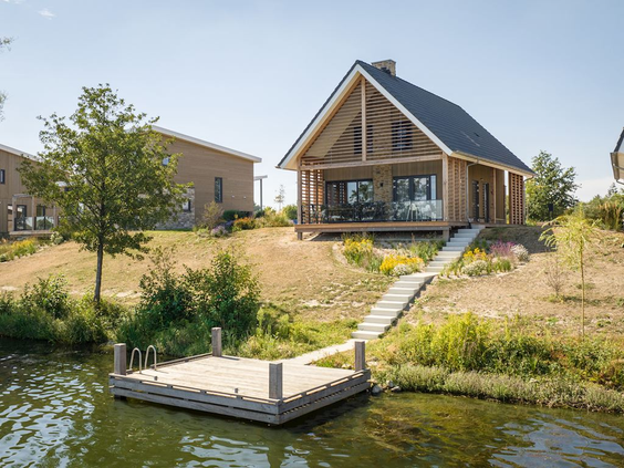 Een luxe houten waterlodge met een eigen aanlegsteiger aan het water op Landal Marina Resort Well.