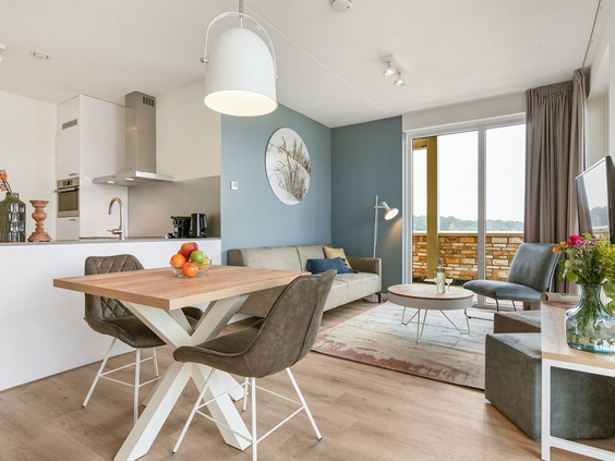 Het lichte en moderne interieur van de woonkamer en eethoek in een vakantiehuis op Landal Marina Resort Well.