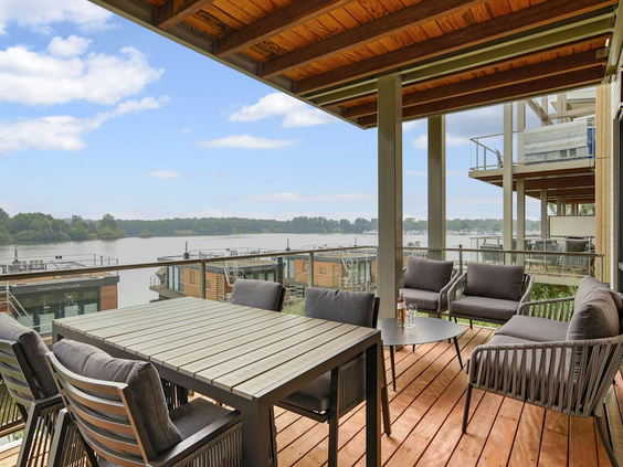 Het ruime balkon van een vakantiewoning met een loungeset en prachtig uitzicht over het water van het Leukermeer.