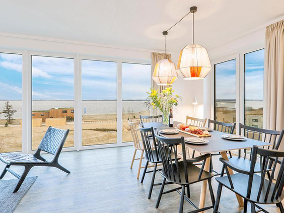 Ruime eetkamer met grote ramen en panoramisch uitzicht over het water en de omgeving bij Landal Marissa.