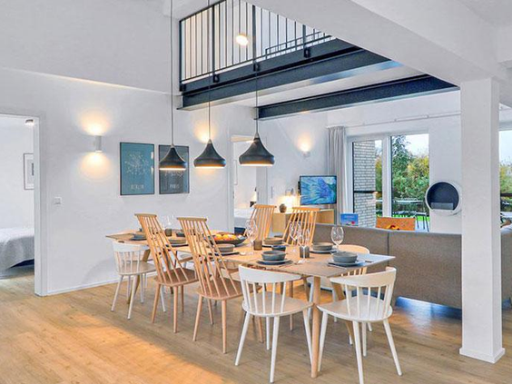 Lichte en ruime eethoek in Landal Marissa met hoge plafonds, moderne inrichting en een vide, ideaal voor grote gezinnen.