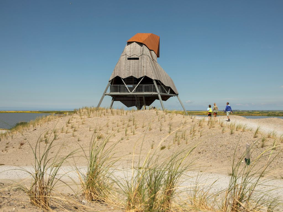 De imposante houten vogelkijkhut 'de Steltloper' die bovenop een duin op de Marker Wadden staat en uitkijkt over het water.