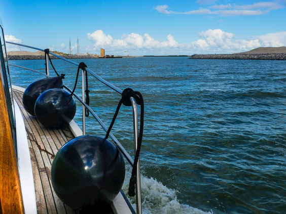 Uitzicht vanaf de reling van de veerboot die over het golvende Markermeer naar de eilandengroep de Marker Wadden vaart.