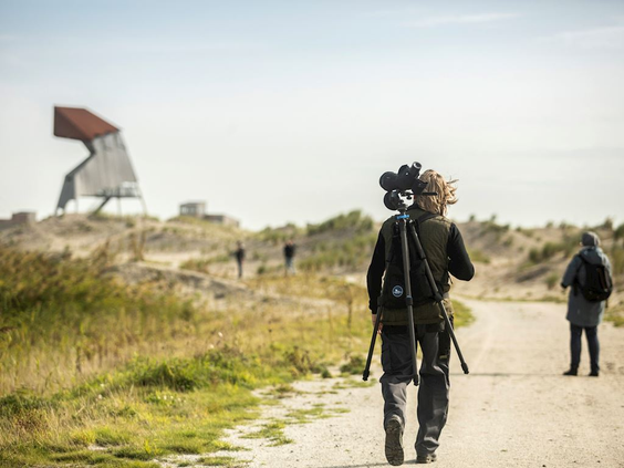 Wandelaars op een zandpad door de duinen op weg naar de vogelkijkhut 'de Steltloper' op de Marker Wadden.