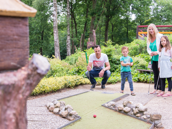 Gezin speelt een potje midgetgolf op de avontuurlijke midgetgolfbaan van Landal Miggelenberg.