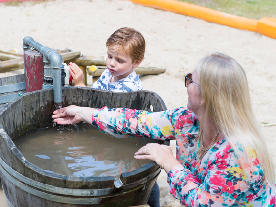 Kinderen spelen met een waterpomp en zand in de waterspeeltuin op vakantiepark Landal Miggelenberg.