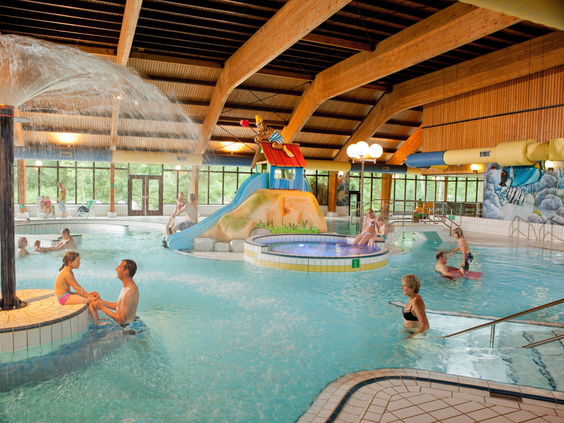 Overzicht van het binnenzwembad van Landal Miggelenberg met een peuterbad, bubbelbad en glijbaan.