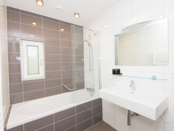 Moderne badkamer met een comfortabel bad in een van de bungalows op Landal Miggelenberg.