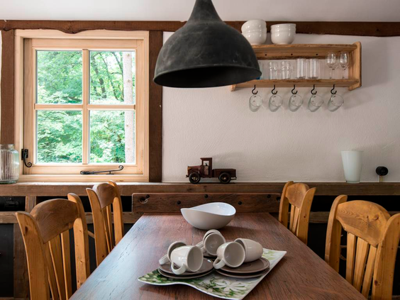 Gezellige houten eethoek in een themabungalow op Landal Miggelenberg, met uitzicht op het bos.